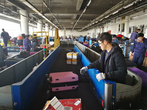 1486626606039054537.jpg 2参与帮忙行李分拣人员耐心地在转盘处进行分拨行李。_副本.jpg