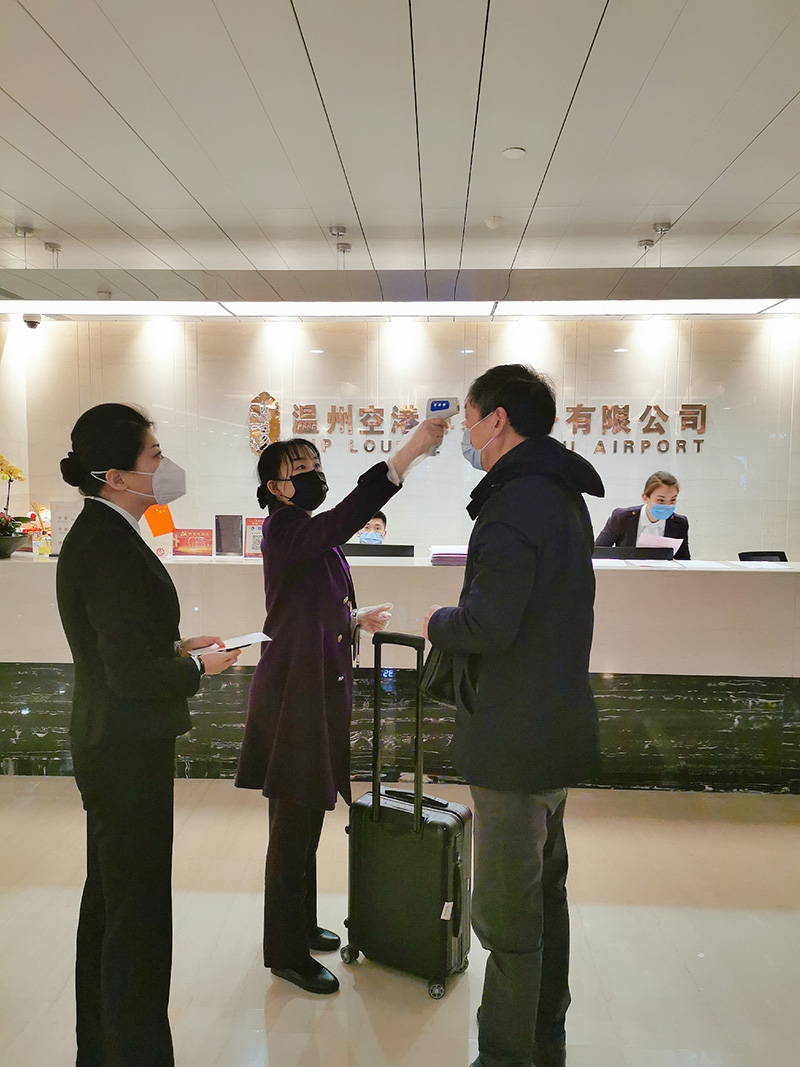 疫情防控期间的尊易巾帼文明岗岗员为旅客测量体温.jpg